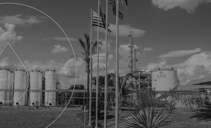 imagem preto e branco da refinaria de petróleo SSOil Energy com bandeiras em mastro e marca d'água da empresa